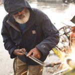 Welder wearing a carhartt jacket